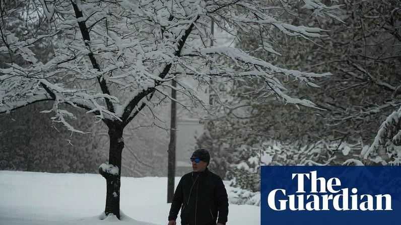 A lone walker in Washington Park, Denver, as a winter storm sweeps over the region. Photograph: David Zalubowski/AP