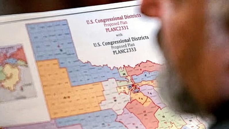 Texas lawmaker Matt Morgan, a Republican, holds a map of the proposed congressional districts. Photograph: Sergio Flores/Reuters