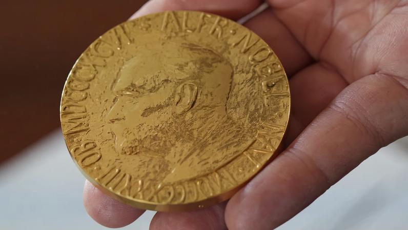An employee of the Norwegian Nobel Institute holds a replica of a Nobel Peace Medal in the Institute in Oslo, Norway, September 9, 2025. REUTERS/Tom Little