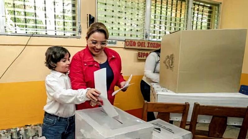 Hondura’s outgoing president, Xiomara Castro, casts her vote accompanied by her grandson Jose Manuel in the city of Catacamas.