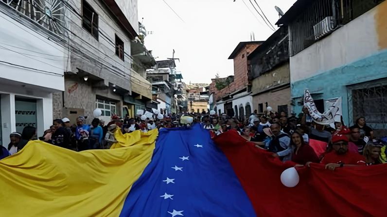 Supporters of the Venezuelan government hold a giant flag at a protest against the US seizure of an oil tanker transporting Venezuelan oil.
