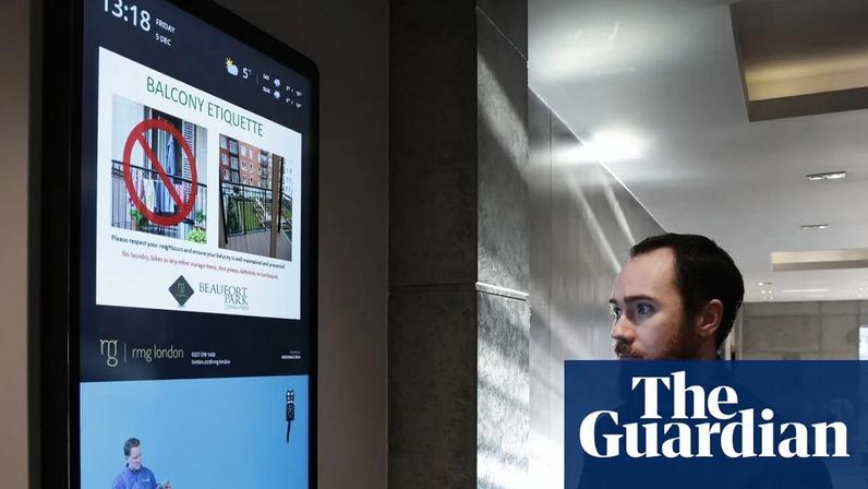Conor Nocher in front of the digital noticeboard at his apartment block in Colindale, north-west London. Photograph: Martin Godwin/The Guardian
