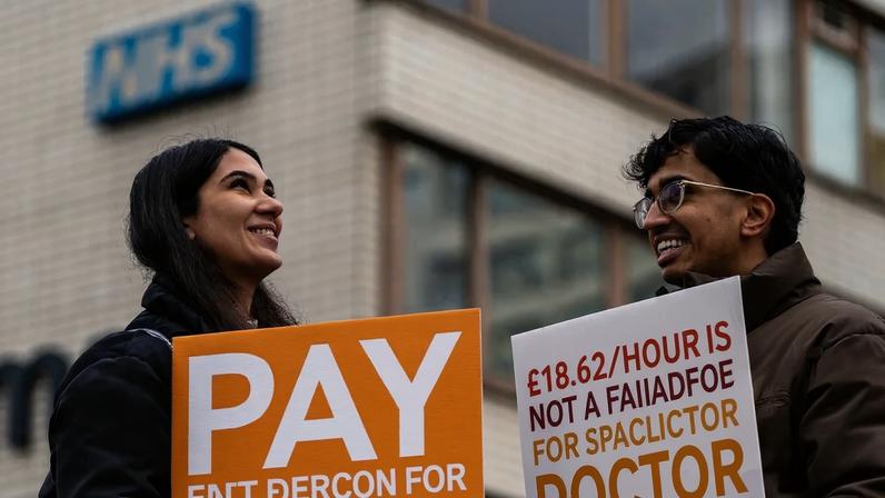 Demonstrators holding up placards outside St Thomas’ hospital in London on 17 December