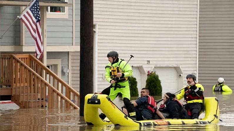 Rescue personnel evacuate a brother and sister who were stranded in their home in an area flooded by the Snohomish River in Washington on Thursday.