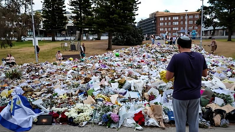 The flowers and mourners at the memorial at Bondi Pavilion on Sunday.