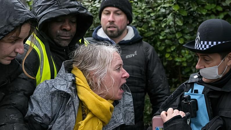Debs Newman is restrained by security staff while protesting about the felling of lime trees in Falmouth on Monday.