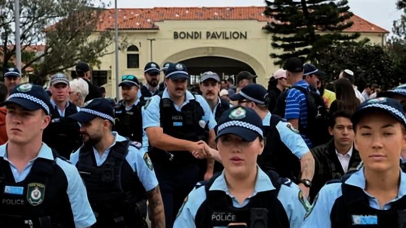 Police officers gather near the Bondi pavilion at the floral memorial on Monday to honour the victims of Sunday’s shooting. Photograph: Flavio Brancaleone/Reuters
