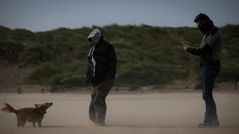 Dogwalkers out in strong winds in Northern Ireland in August. There are yellow and amber warnings for wind and rain across the UK into Tuesday. Photograph: Charles McQuillan/Getty Images