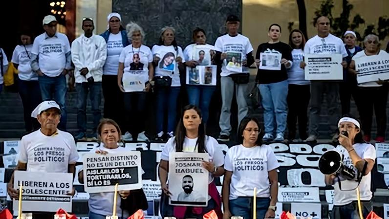 Familiares de presos políticos en Venezuela sostienen carteles en una manifestación este domingo, en Caracas (Venezuela).
