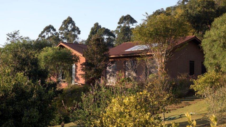 TERRENO | A casa foi construída do zero em um sítio compartilhado por sete famílias, sem divisão de lotes, que no início era apenas uma área degradada pelo plantio de milho. Regenerado ao longo de 12 anos pelos moradores, o terreno hoje é fértil, com paisagem exuberante, presença de aves, capivaras, macacos e até onças, além de ser autossuficiente em raízes, hortaliças e frutíferas