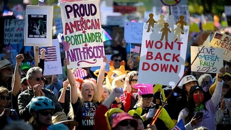 Demonstrators cheer during a speech as protesters gather to march for the "No Kings" protest on 18 October 2025 in Portland, Oregon.