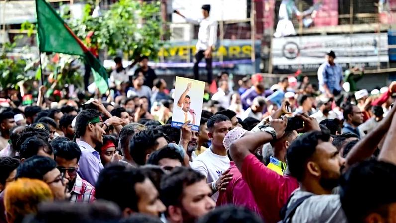 A Bangladesh Nationalist Party activist holds a poster of acting party chairman Tarique Rahman during a rally in Dhaka on Aug. 7, 2024.