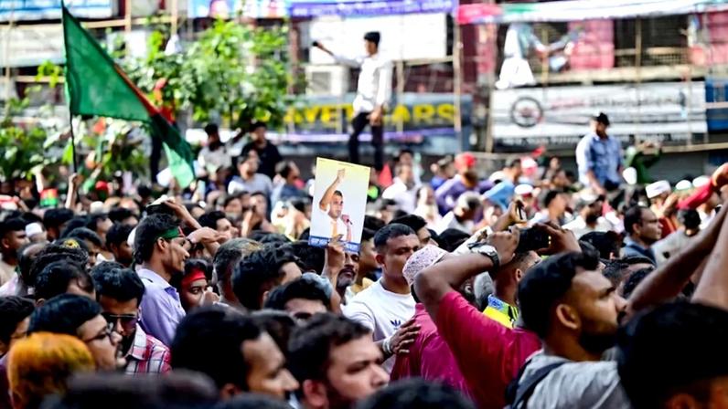 A Bangladesh Nationalist Party activist holds a poster of acting party chairman Tarique Rahman during a rally in Dhaka on Aug. 7, 2024.