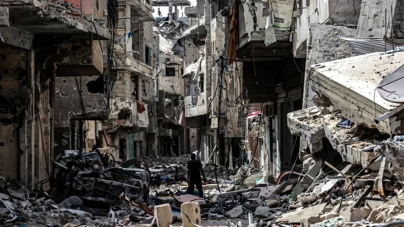 A Palestinian walks on building rubble in Khan Yunis in the southern Gaza Strip on April 22, 2024.