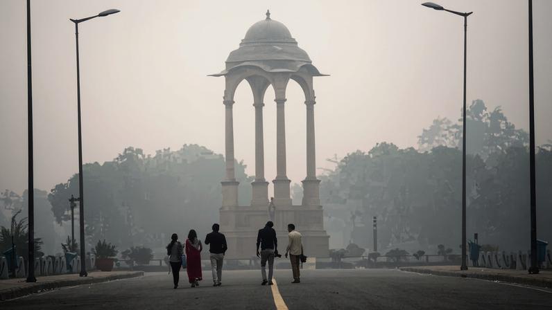 People walk near India gate amid heavy dust and smog November 7, 2016 in Delhi, India.