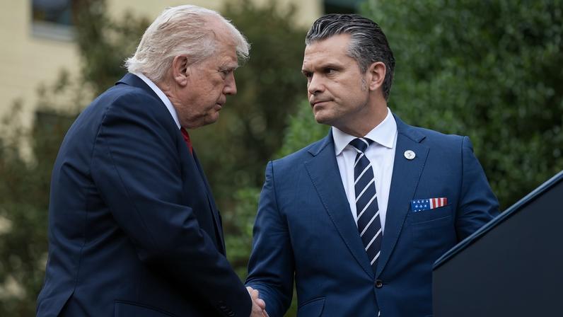 U.S. President Donald Trump shakes hands with U.S. Defense Secretary Pete Hegseth.