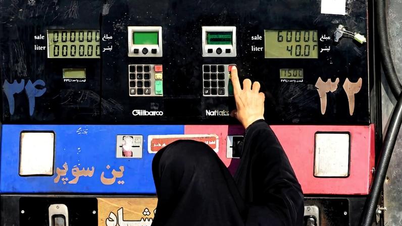 A woman refuels her car at a gas station in Tehran.