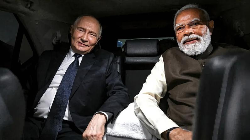 Russian President Vladimir Putin and Indian Prime Minister Narendra Modi sit in a car in New Delhi.