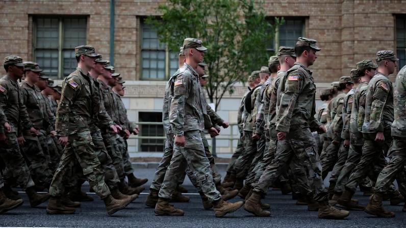 Rows of U.S. soldiers march in formation down a street in Washington, DC.C.