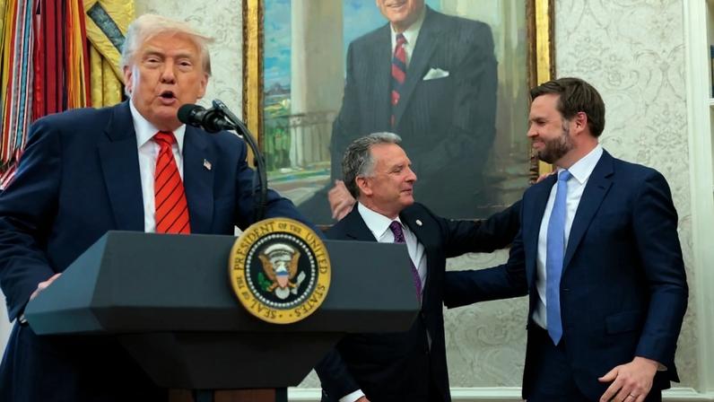 U.S. President Donald Trump delivers remarks as Vice President J.D. Vance and special envoy Steve Witkoff embrace at the White House in Washington.
