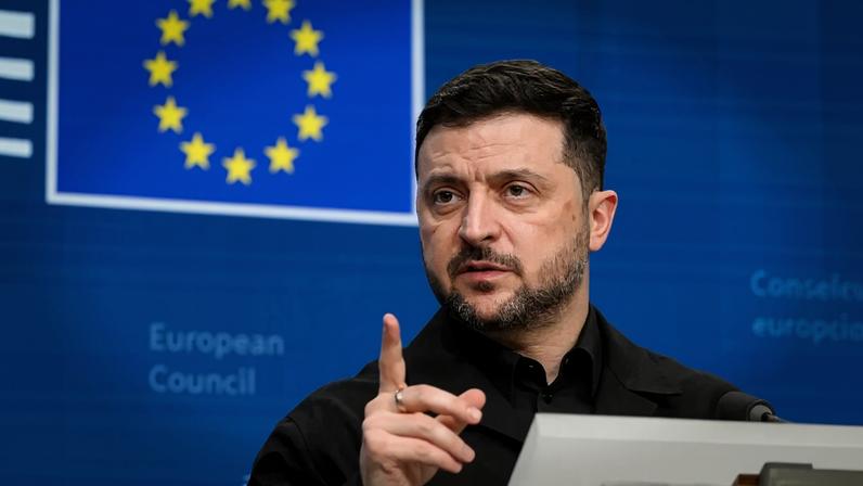 Ukrainian President Volodymyr Zelensky speaks during a press conference in front of a European Union flag.