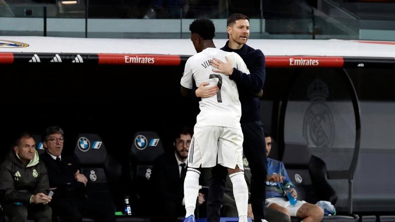 Vinícius Júnior abraça o técnico Xabi Alonso ao deixar o jogo contra o Sevilla — Foto: Oscar DEL POZO / AFP