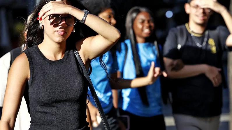 Pessoas se protegem do sol na região central da cidade durante onda de calor - Foto: Fernando Frazão/Agência Brasil