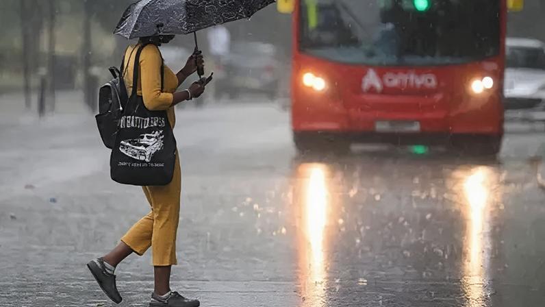 Getty Images A woman wearing an umbrella in heavy rain