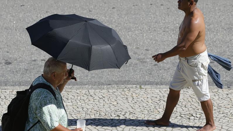 Pessoas se protegem do sol no centro da cidade em dia de calor no Rio de Janeiro. Foto: Fernando Frazão/Agência Brasil