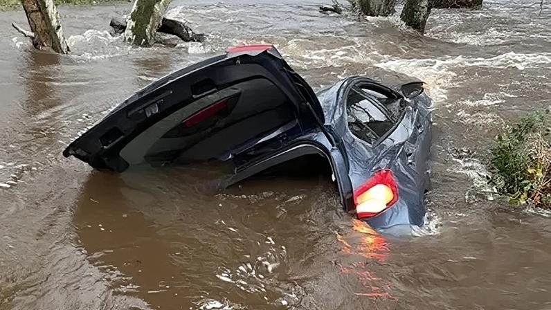 A member of the public rescued a driver after their car was swept downstream
