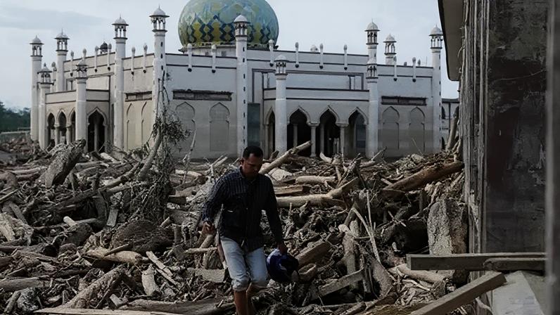 Reuters A man walks through a village destroyed by flooding