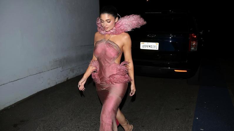 Kylie Jenner wore a pink feathered dress to her Kylie Cosmetics holiday party on Wednesday night.
