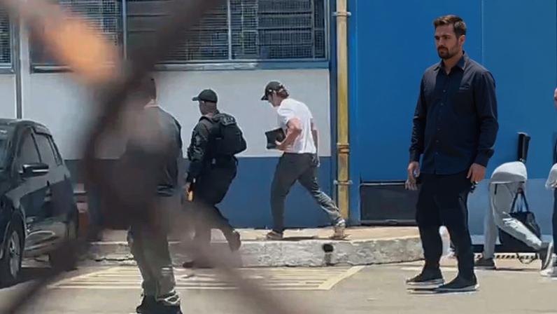 Daniel Vorcaro (no destaque) deixa a prisão usando boné e camiseta branca — Foto: Reprodução/Arquivo pessoal e Bruna Vieira/TV Globo