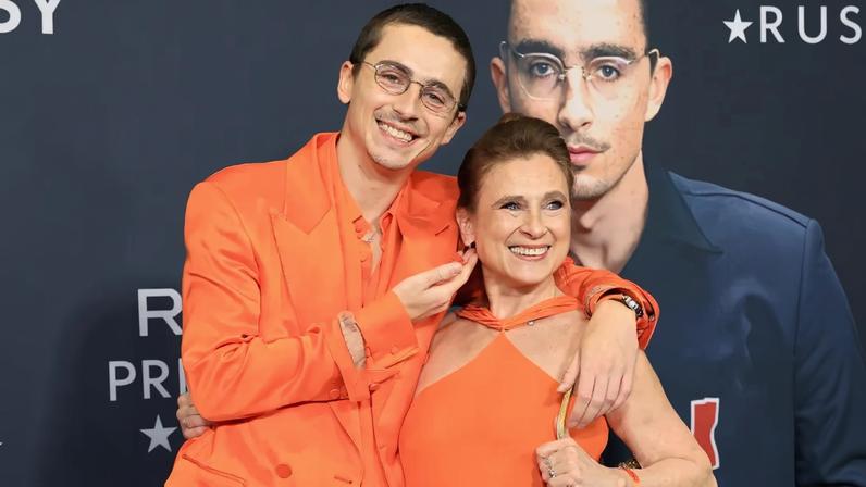 Timothée Chalamet and his mom, Nicole Flender, matched in neon orange at the “Marty Supreme” NYC premiere on Dec. 16. WireImage