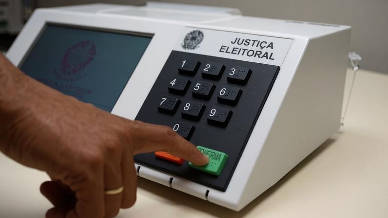 Mão apertando tecla em urna eletrônica — Foto: Divulgação
