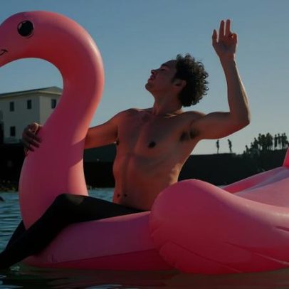 Silvero Pereira usa boia de flamingo em praia de Salvador