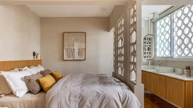 Os cobogós no quarto de hóspedes criam luz e sombra na decoração repleta de tons neutros
