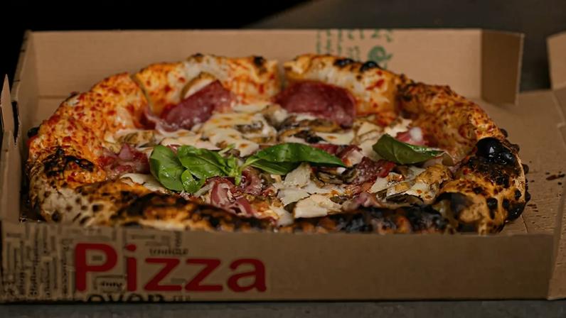 Fotografia de uma pizza dentro da caixa.