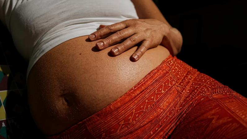 Fotogravia de uma barriga de uma mulher grávida.