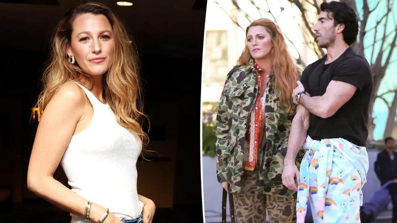 Blake Lively standing in a cinema, wearing a white tank top and blue jeans with floral cutouts.