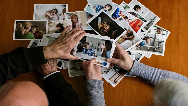 Fotografia de um casal de idosos olhando fotos.