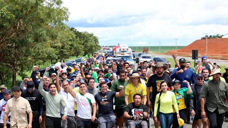 Deputado Nikolas Ferreira caminha na rodovia BR-040 em protesto contra prisão de Bolsonaro.