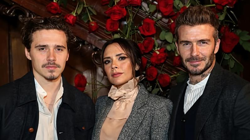 Brooklyn Peltz Beckham with his parents, David and Victoria Beckham with flowers behind posing for camera