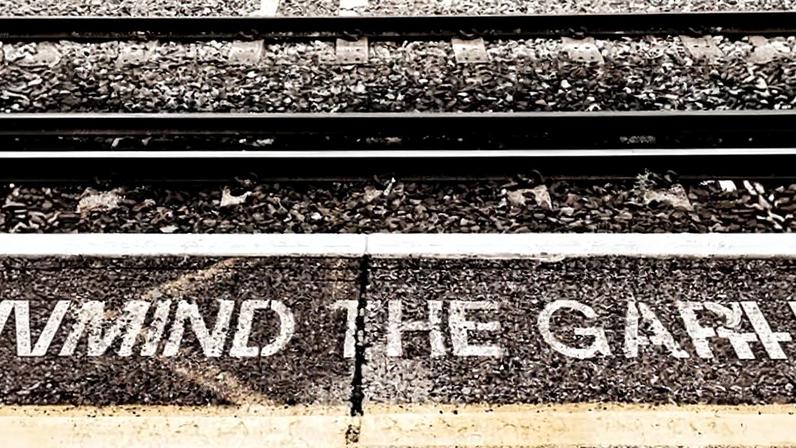 Mind the gap sign and yellow line on a rail platform