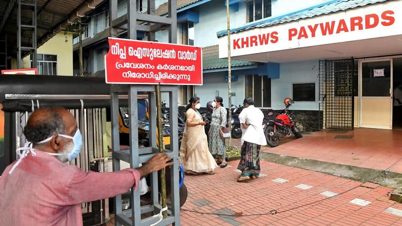 Funcionários instalam placa com os dizeres "Área de isolamento do Nipah, entrada estritamente proibida" em hospital no distrito de Kozhikode, em Kerala, na Índia