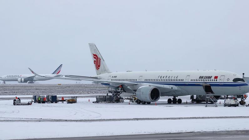 An Air China plane is seen on the snow-covered tarmac at the Paris CDG Terminal 1 of the Paris-Charles de Gaulle Airport, in Roissy-en-France, near Paris, as traffic is disrupted and some flights cancelled due winter weather with snow and cold temperatures on part of the country, France, January 7, 2026. REUTERS/Abdul Saboor