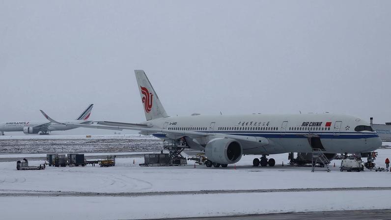 An Air China plane is seen on the snow-covered tarmac at the Paris CDG Terminal 1 of the Paris-Charles de Gaulle Airport, in Roissy-en-France, near Paris, as traffic is disrupted and some flights cancelled due winter weather with snow and cold temperatures on part of the country, France, January 7, 2026. REUTERS/Abdul Saboor