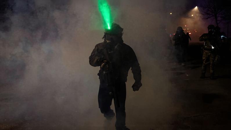 A member of federal law enforcement walks through tear gas after using the chemical on angered community members, as tensions rise after federal law enforcement agents were involved in a shooting incident, a week after a U.S. Immigration and Customs Enforcement (ICE) agent fatally shot Renee Nicole Good, in Minneapolis, Minnesota, U.S., January 14, 2026. REUTERS/Seth Herald