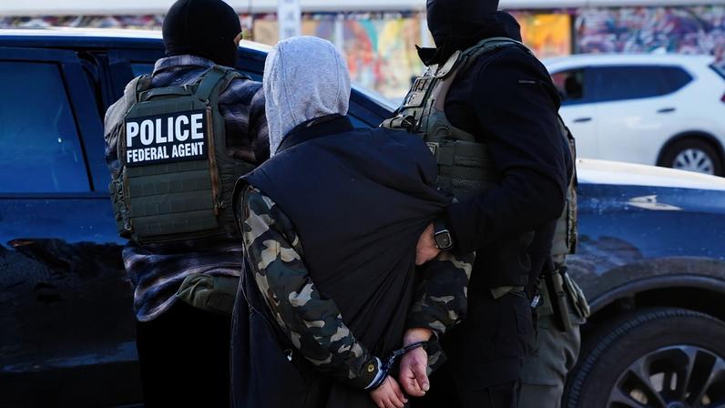 FILE PHOTO: Federal agents detain a person at a bus stop as they conduct an immigration raid days after a U.S. Immigration and Customs Enforcement (ICE) agent fatally shot Renee Nicole Good, in Minneapolis, Minnesota, U.S., January 14, 2026. REUTERS/Ryan Murphy/File Photo