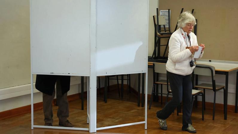 A woman walks from a voting booth during the presidential election in Lisbon, Portugal, January 18, 2026. REUTERS/Pedro Nunes